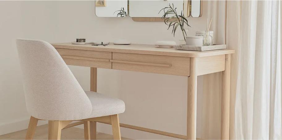 Minimalistyczna toaletka z naturalnego drewna, wyposażona w szuflady.