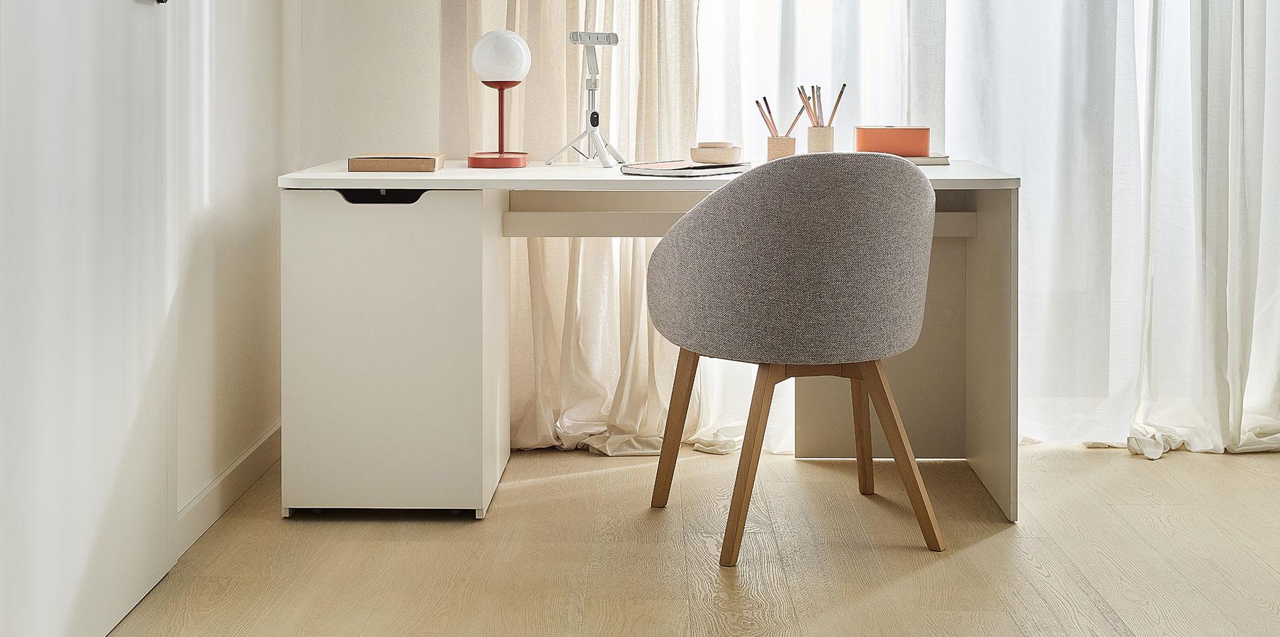 Eleganckie biurko w jasnych tonacjach z designerskim fotelem.