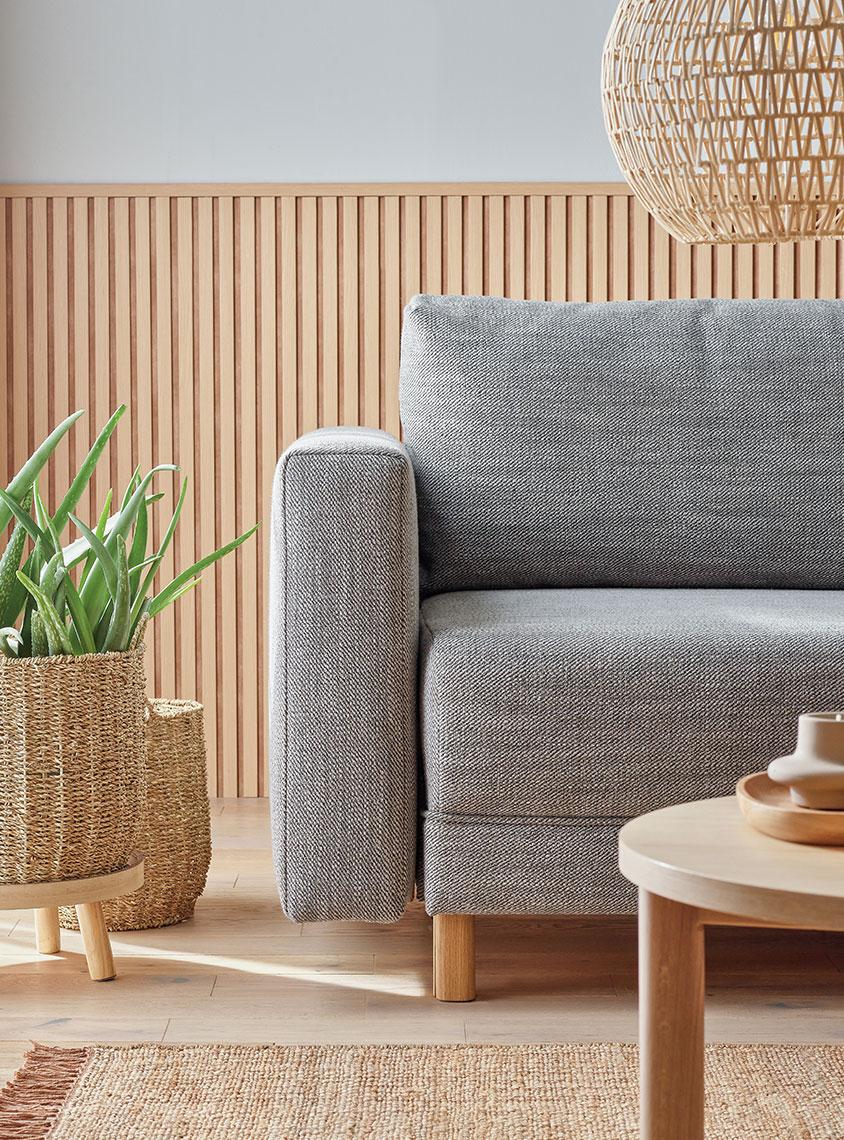 szara sofa w salonie w barwach dębu