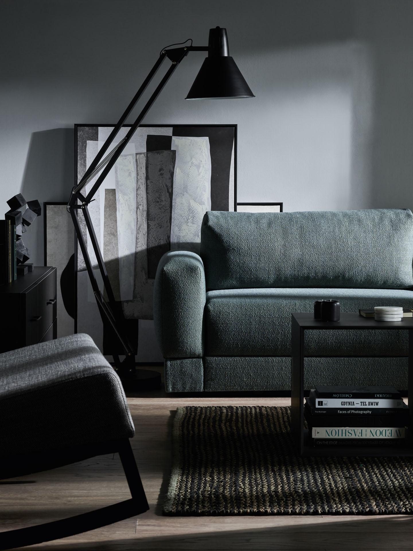 ciemnoniebieska sofa na tle szarej ściany