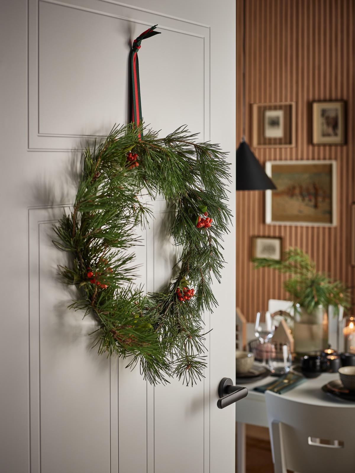 bożonarodzeniowy wieniec zawieszony na białych drzwiach
