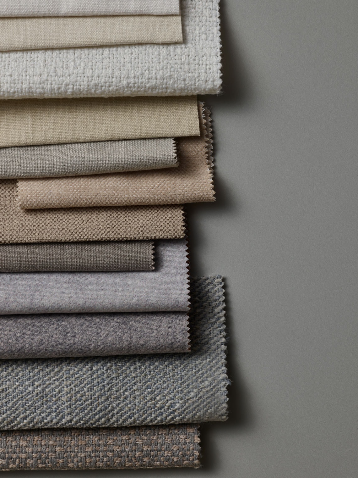 Próbki tkanin w odcieniach beżu i szarości