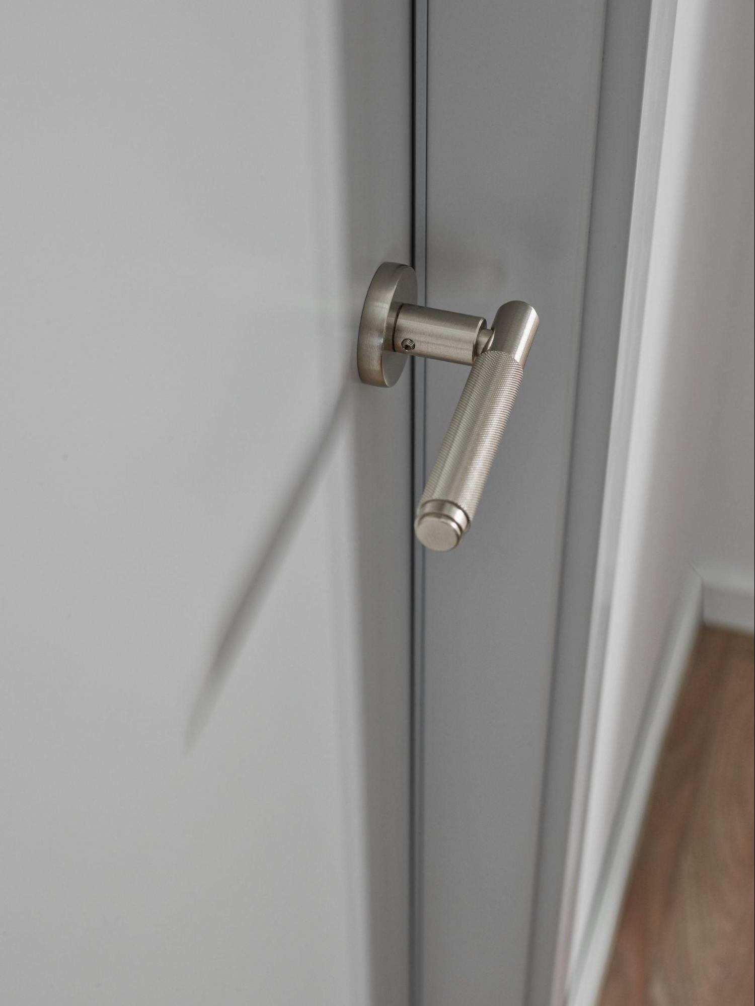 Szare drzwi ze srebrną klamką