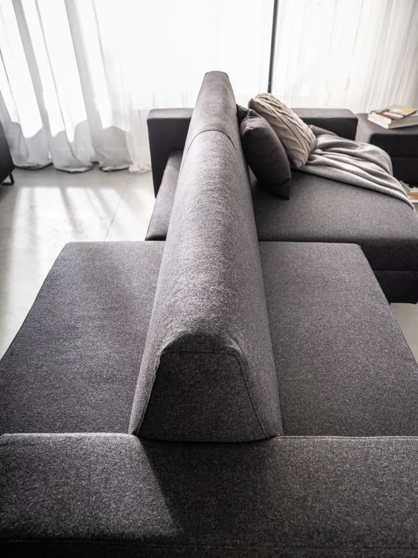 Ciemnoszara sofa z wysokim zagłówkiem w nowoczesnym salonie