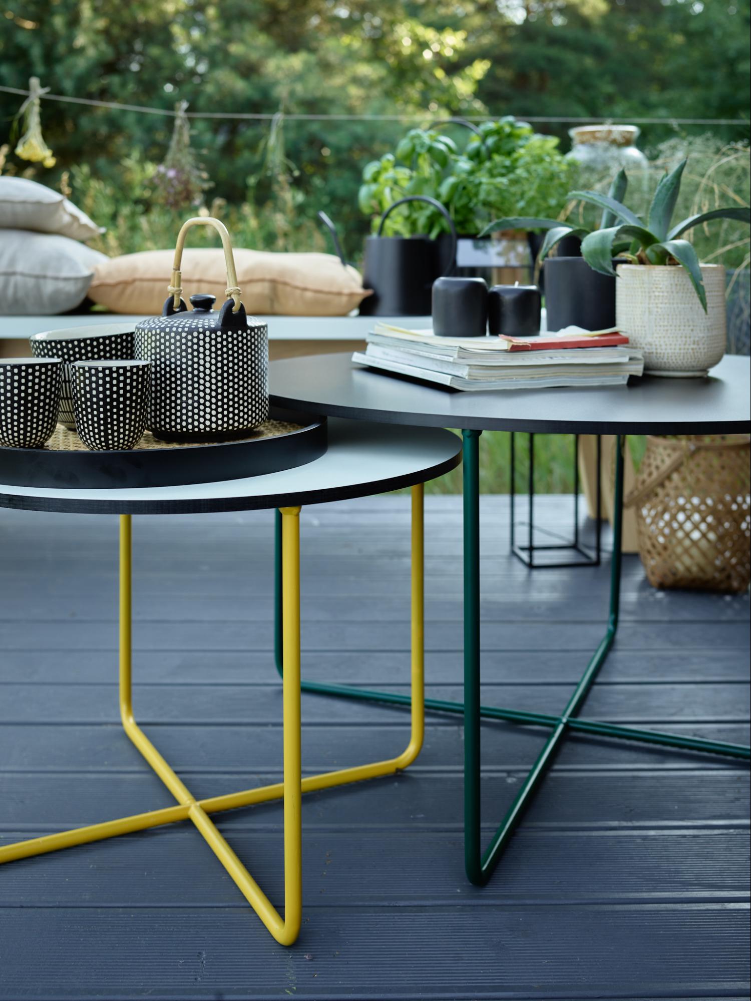 dwa stoliki kawowe na tarasie zastawione naczyniami i dekoracjami