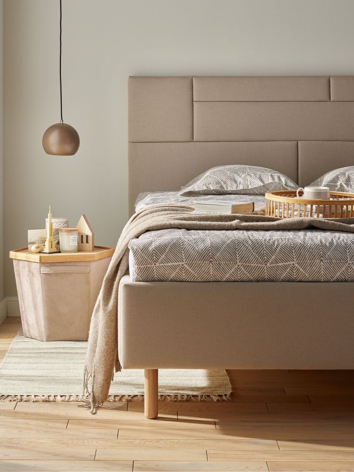 łóżko tapicerowane w beżowej tkaninie