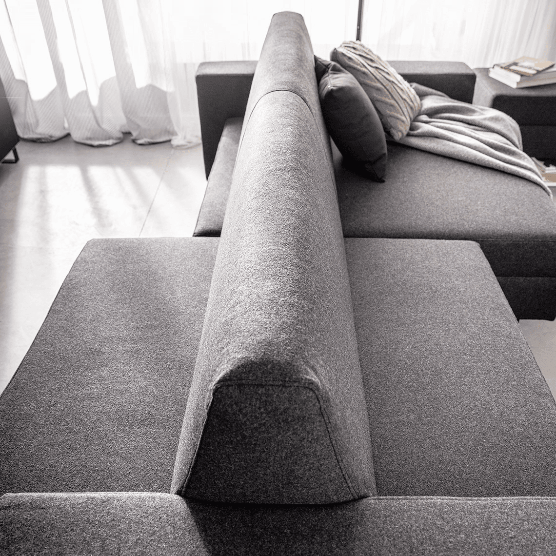 Oparcie szarej sofy z ruchomymi siedziskami