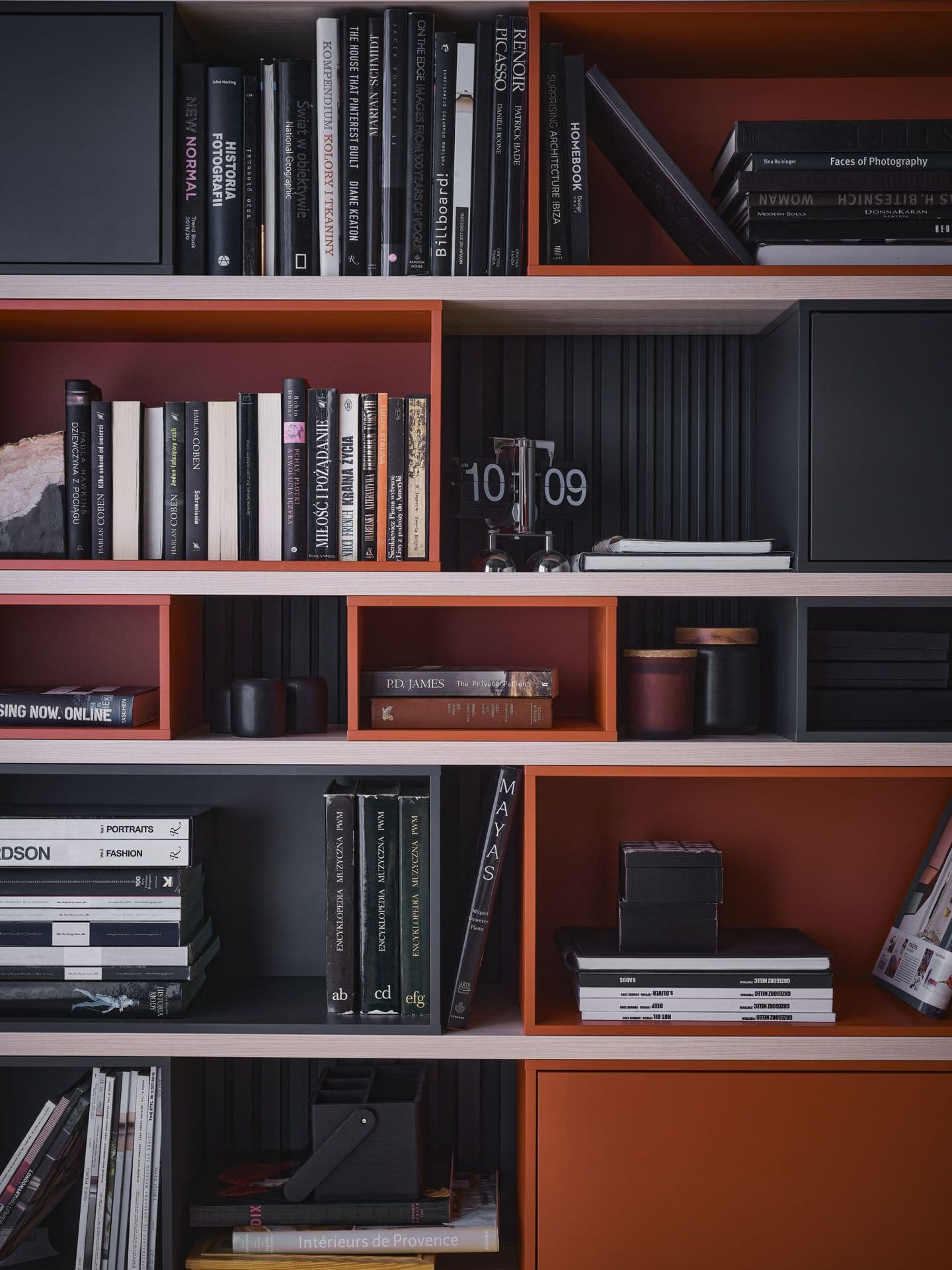 Półki z książkami w czarno-czerwonej aranżacji