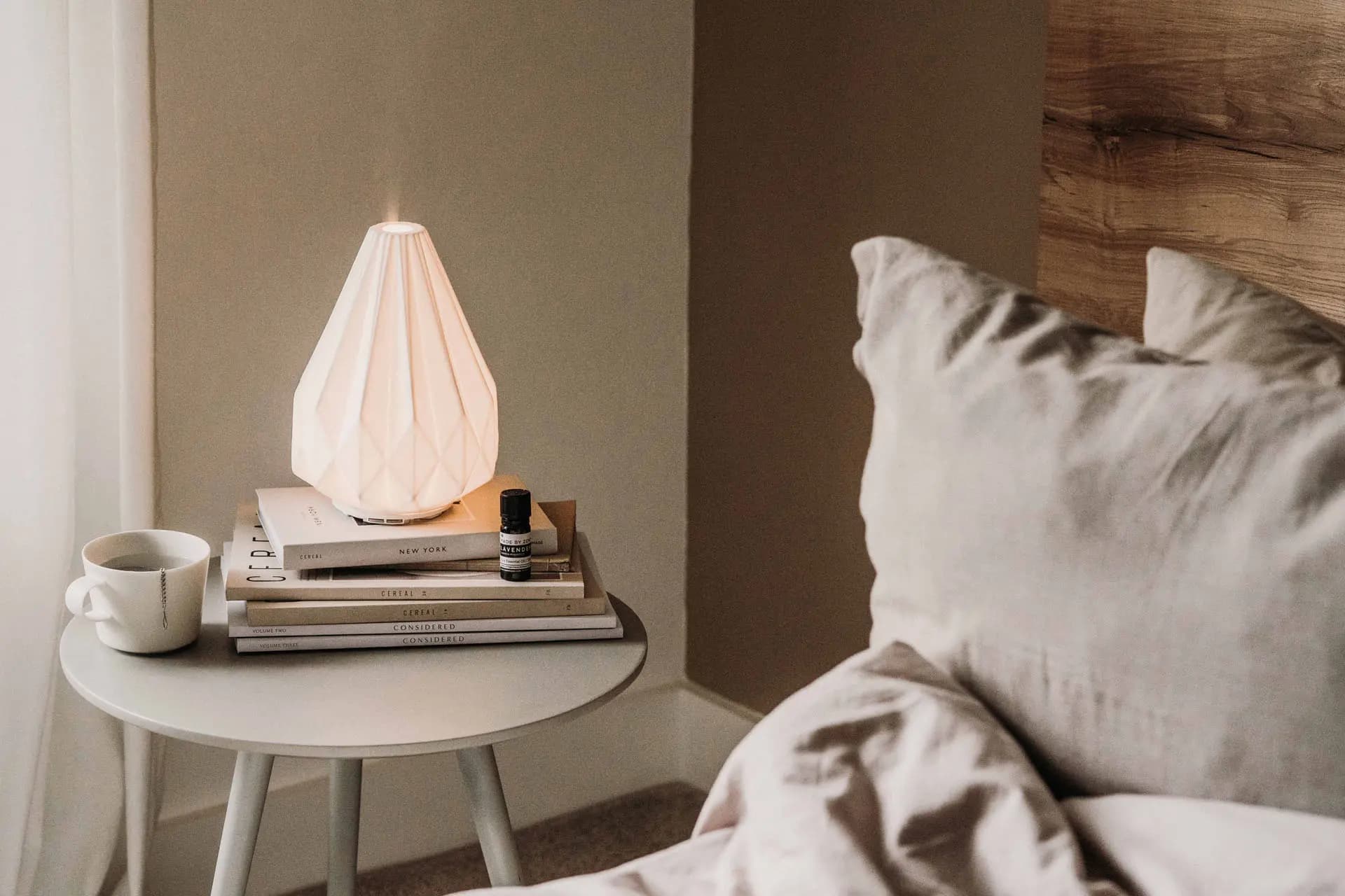 Świecący dyfuzor zapachowy na szafce nocnej.