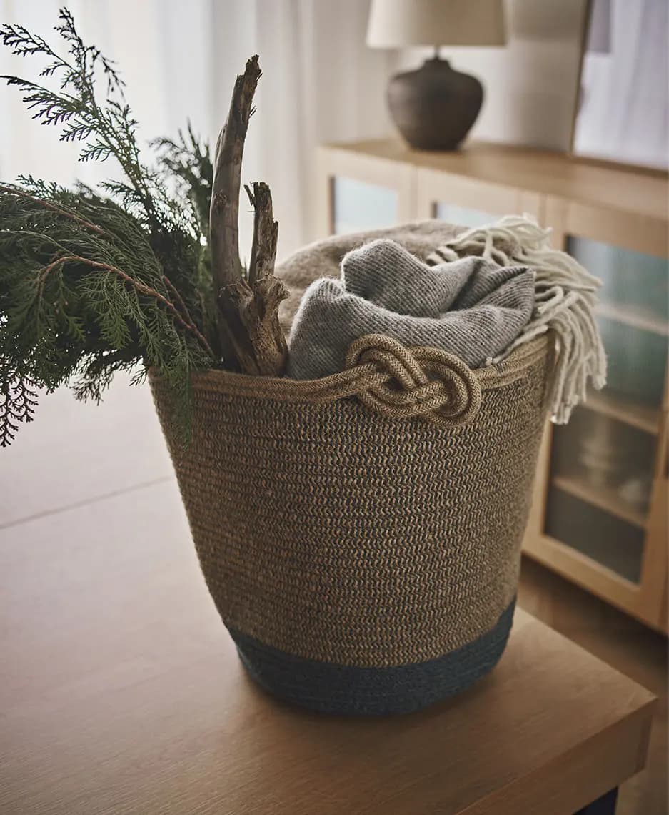 Pleciony kosz z naturalnymi dodatkami – przytulny detal we wnętrzu
